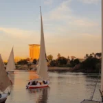 Felucca navegando por el Nilo al atardecer en Asuán durante el crucero por el Nilo