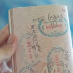 Persona sosteniendo un pasaporte abierto con sellos de visado
