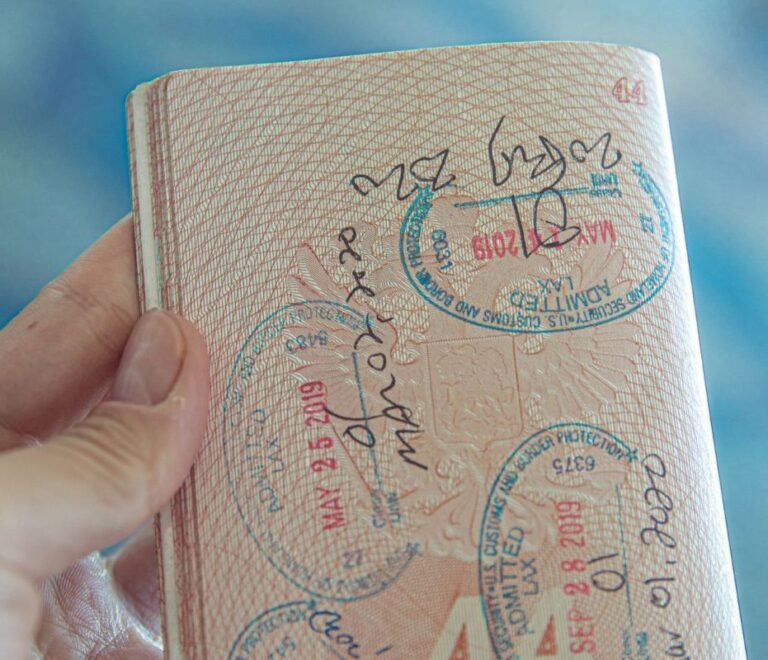 Persona sosteniendo un pasaporte abierto con sellos de visado