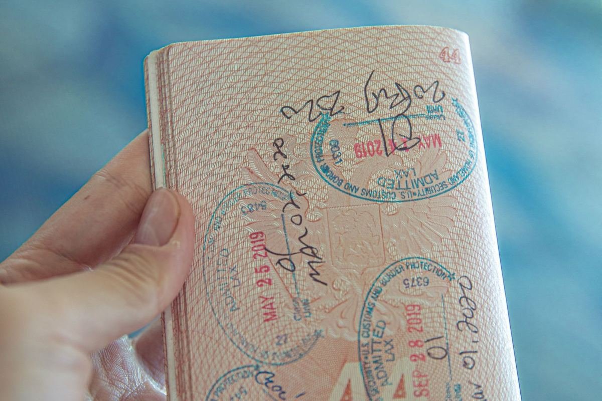 Persona sosteniendo un pasaporte abierto con sellos de visado